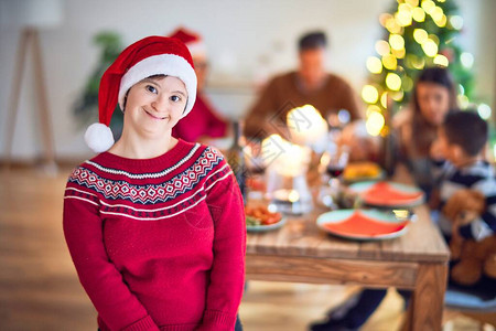 年轻漂亮的女人微笑着快乐而自信戴着圣诞老人帽站在家里庆祝圣诞图片