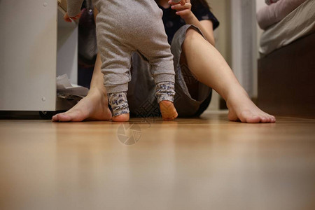 婴儿走向母亲小孩子走在卧室的木地板上妈坐着等温暖爱的家庭观念孩子们成图片