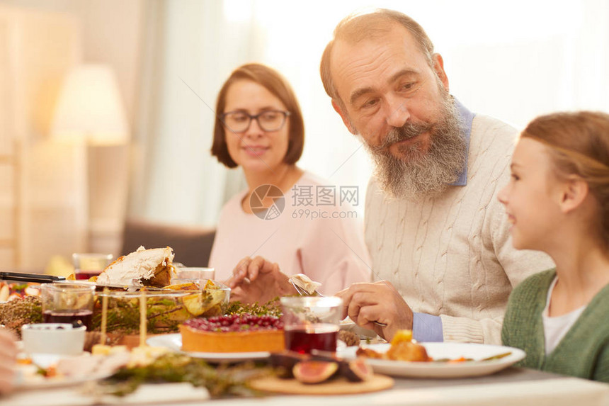 长胡子的老人和大胡子坐在桌边与小女孩坐在一起图片