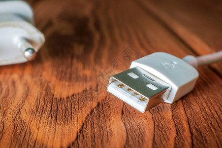 木制表面的USB充电器缆受损用图片