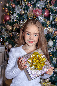 圣诞树附近的小可爱女孩新年和圣诞节圣诞树装背景图片
