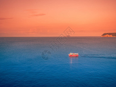 库存照片在海上的日落与一艘小船航行图片