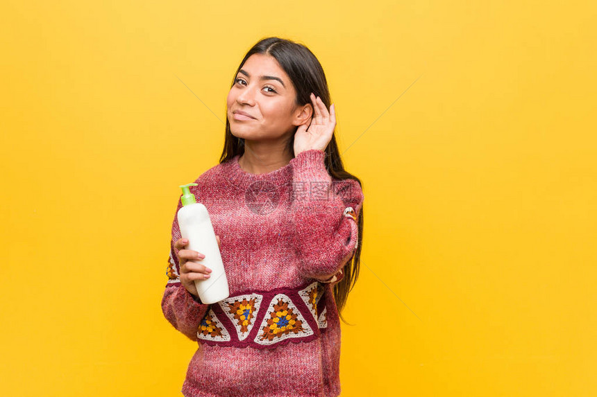 年轻阿拉伯女人拿着奶油瓶想图片