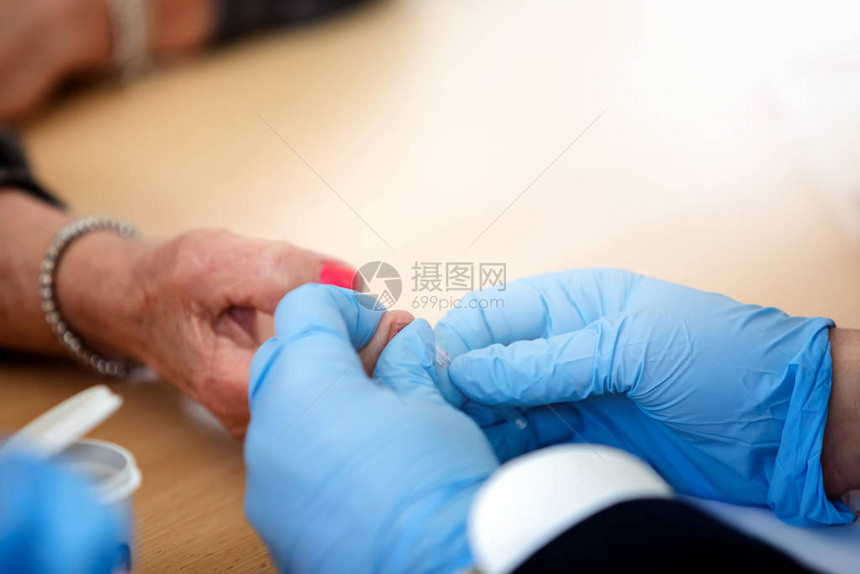 老年妇女血液中的血糖控制用小针从病人的手图片
