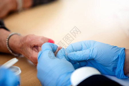 药筒老年妇女血液中的血糖控制用小针从病人的手背景