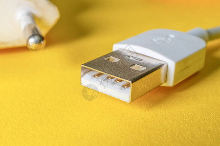 在黄色表面损坏的USB充电器缆图片