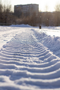 冬天雪地里拖拉机的新鲜履带清雪背景图片