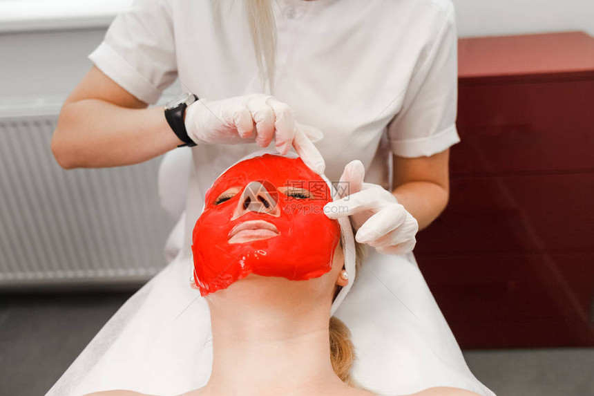 美容师将滋养面膜敷在患者脸上图片