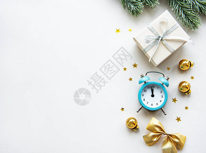 白色背景上带有闹钟和圣诞装饰品的平躺组合物背景图片