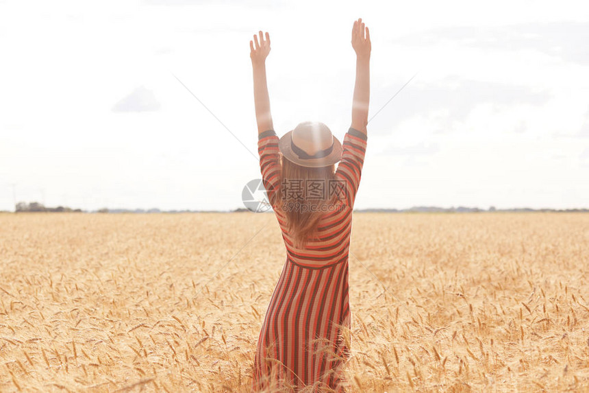 身材高大的年轻女子正将双臂伸向太阳图片