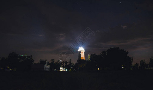 闪亮的灯塔映衬着繁星点的夜空图片