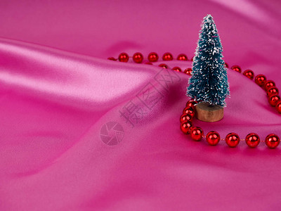 圣诞树以闪亮的粉红色缎子为背景图片