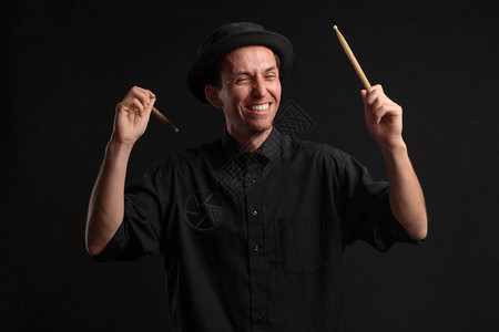 时髦的男子鼓手穿着黑色衬衫和帽子图片