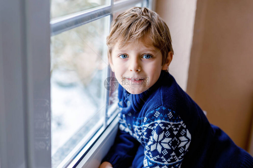 快乐可爱的男孩坐在窗边图片