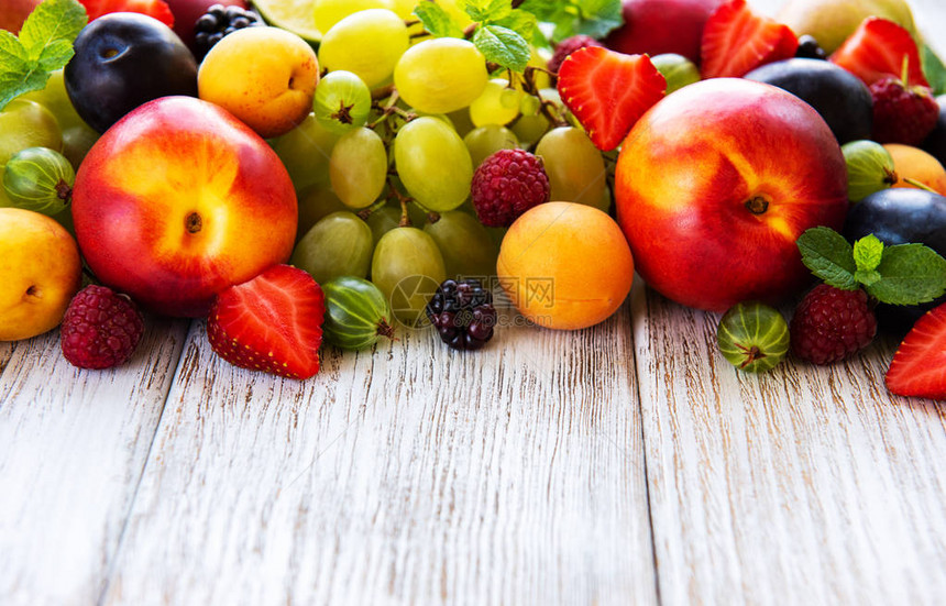 白色木桌上的新鲜夏季水果和浆果图片