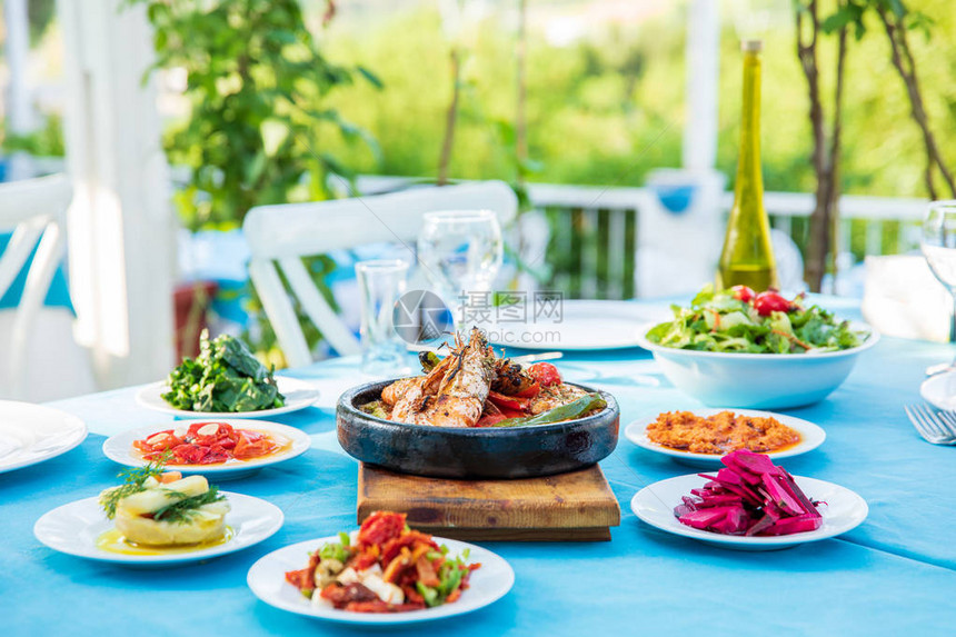 鱼餐厅桌上的虾海鲜开胃菜和沙拉希腊或土耳其的海滩餐厅博德鲁姆圣托里尼或米科诺斯的爱琴海滨希腊或土耳其图片