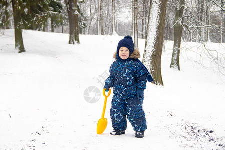 冬天在公园散步的小男孩冬季公园一个穿着冬季工作服的男孩公园里图片