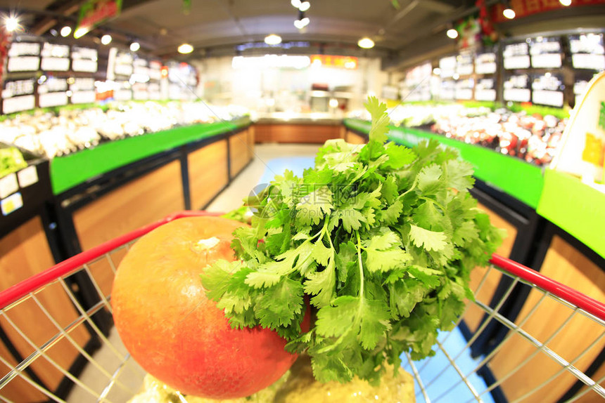 装满蔬菜的购物车在超市里图片