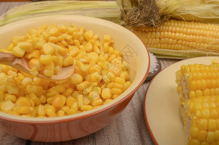 盘子里的甜玉米粒和木桌上的玉米穗健康的饮食健身饮食为了甜蜜图片