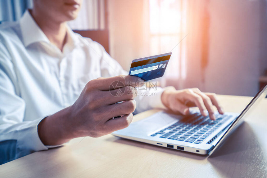年轻人使用信卡在笔记本电脑应用程序或网站上在线购物付款电子商务和网图片