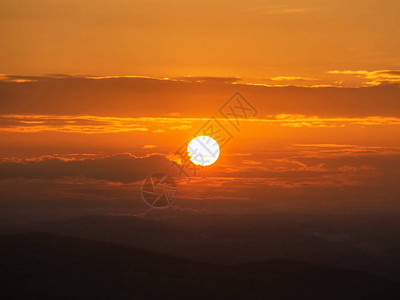 明亮的太阳和戏剧日出天空山底有橙背景图片