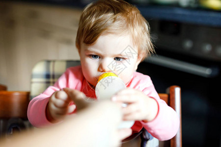 可爱的女婴拿着奶瓶喝配方奶婴儿的第一餐新出生的孩子图片