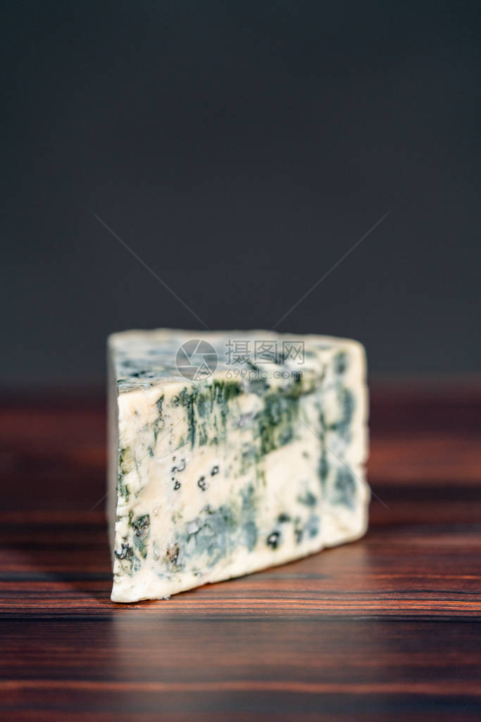深色木质背景上的大块蓝纹奶酪图片