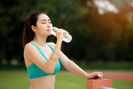 亚洲十几岁的青少年饮用水来自酒瓶图片