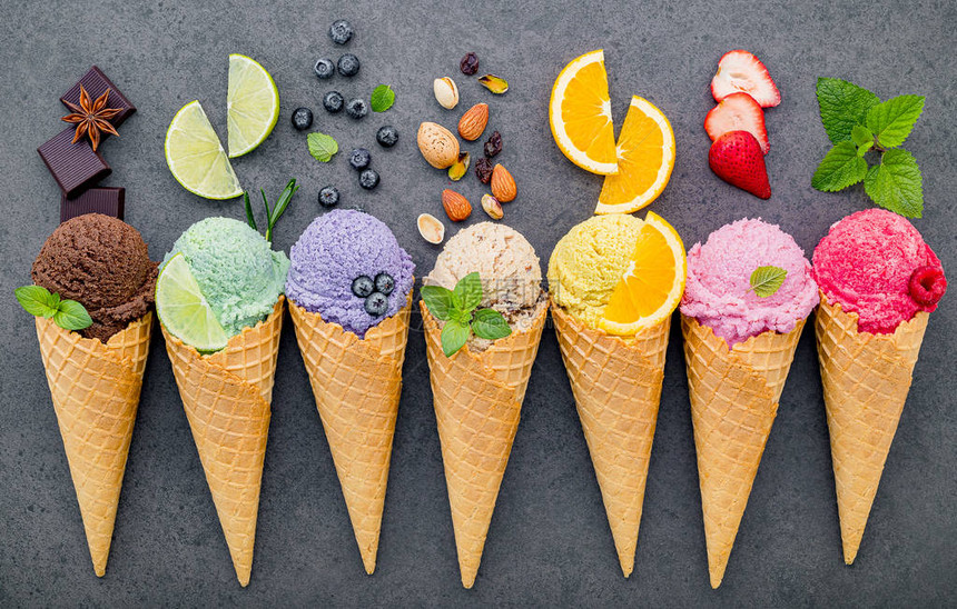 在黑石背景上设置的锥体蓝莓酸橙开心果杏仁橙子巧克力香草和咖啡中的各种冰淇淋风味夏季和甜图片