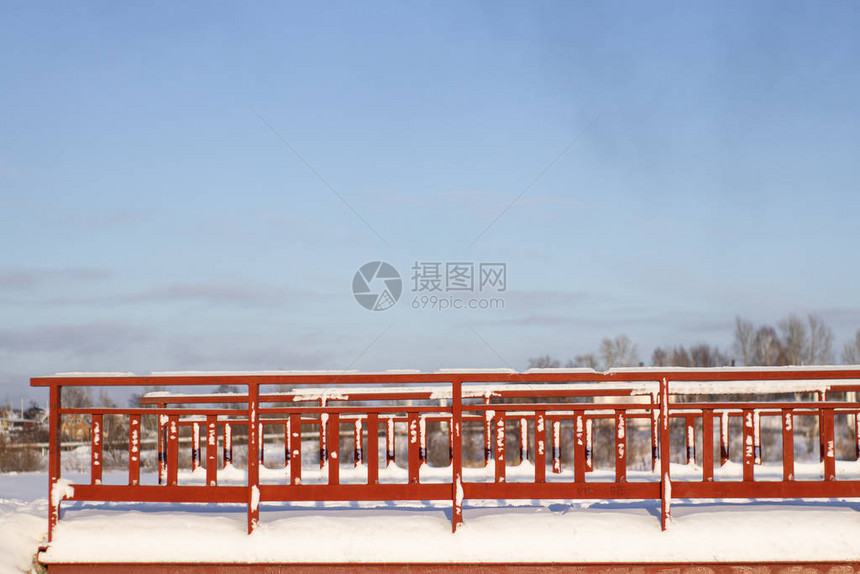 在雪天横渡河面的红金属桥图片
