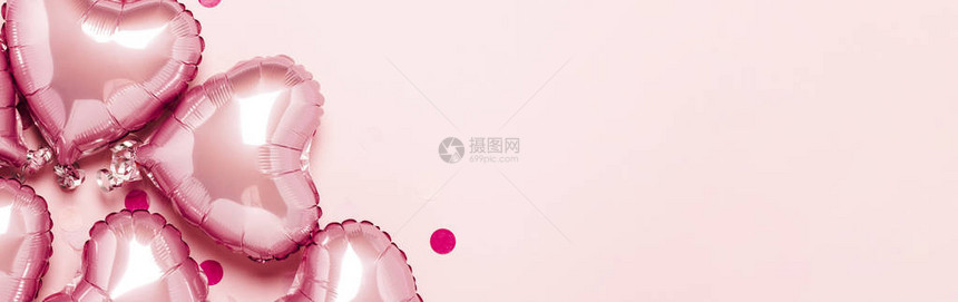 粉红色的气球在粉红色的背景上呈心形情人节装饰婚礼邀请或照片区的概念箔球横幅图片