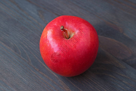 一个红苹果在深彩色木制图片