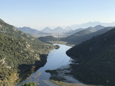 白天森林覆盖的山区之间河流的闪光景色图片