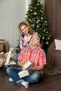 快乐的情人在圣诞树上为图片