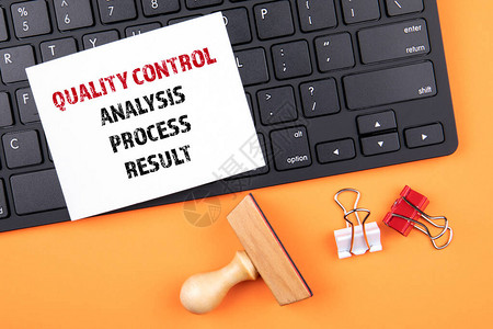 质量控制分析过程和结果概念橙色桌上的黑计算图片