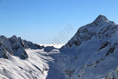 在云彩蓝天的雪山峰顶图片