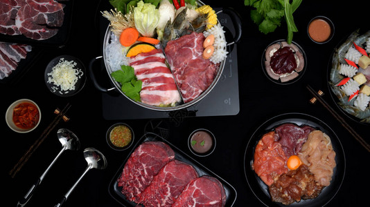 热锅新鲜切片肉海鲜食品蔬菜和黑底食鱼酱日本菜中ShabuShab图片