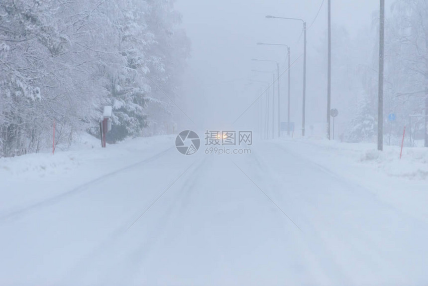 496号公路在芬兰Tuupovaara冬季被大雪和恶劣天气所覆盖图片