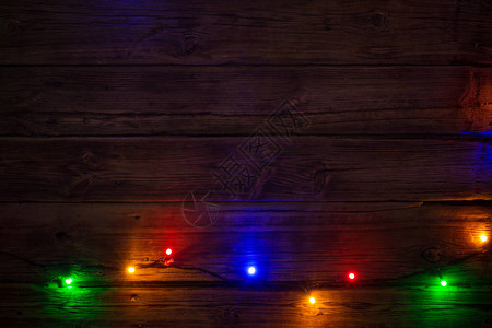 木制表面圣诞节和新年背景有多色灯泡图片
