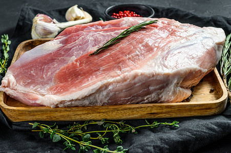 新鲜猪肉切片香料生肉后腿牛排黑色背背景图片