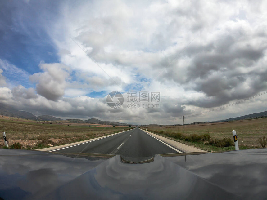 在两路柏油路上驾驶一辆黑色汽车图片