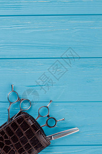 时尚专业理发剪刀蓝色木制桌子上的美发剪图片