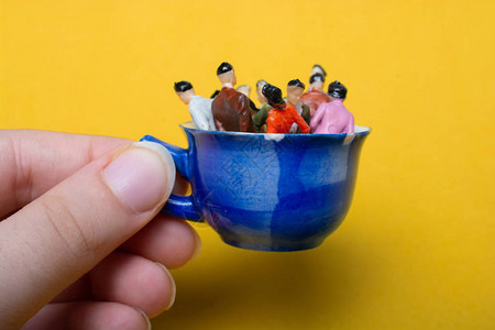 微型人商业团队站在杯子上图片