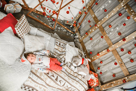 婴儿躺在红色和白色的圣诞背景图片