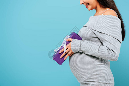 部分地看到微笑着的怀孕的漂亮女孩穿着蓝图片