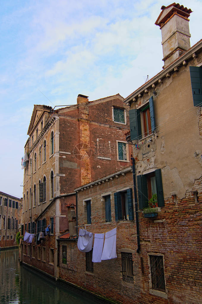 威尼斯的中世纪红砖建筑倒映在碧绿的水中衣服在墙上的绳子上晾干城市的非旅游部分意大利威图片