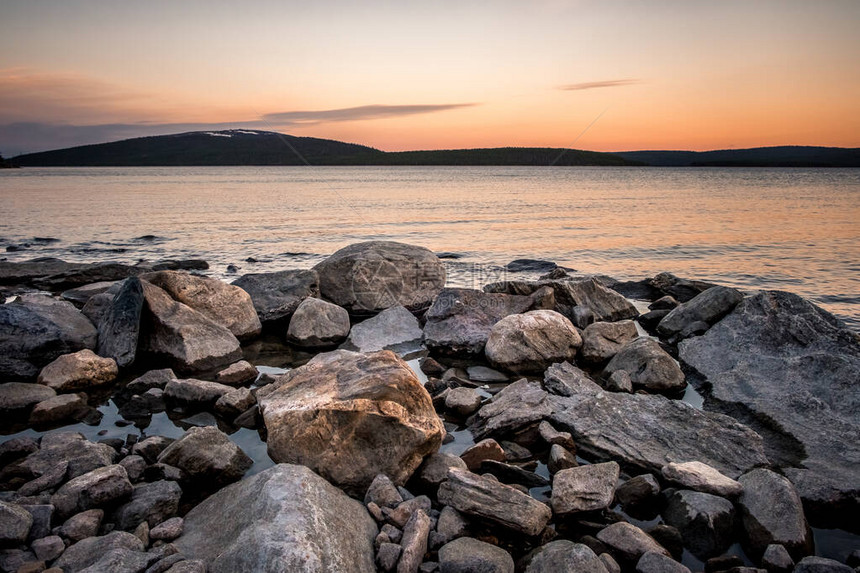 日落时白海岸的石块冷冻的水夏图片