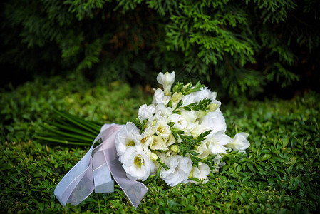 黄色和白色玫瑰的婚礼花束以及躺在木地板图片
