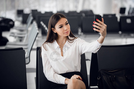 国际机场的年轻女子用手机自拍图片