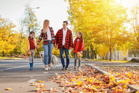 走在秋天公园的幸福一家人图片